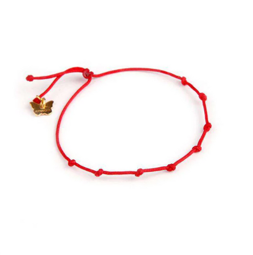 Red bracelet with a gold charm on a white background